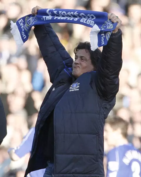 U. S. actor Stallone holds a scarf as he walks on the pitch at the English Premier League match betwe