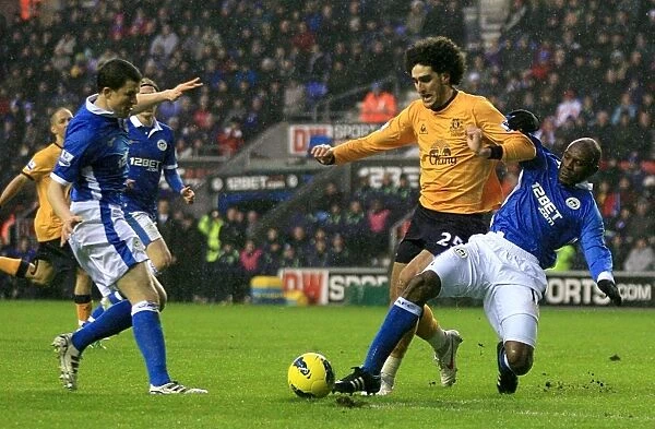 Everton's Fellaini Fights for Ball Against Wigan Athletic Duo in Premier League Clash