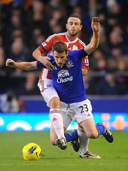 Intense Rivalry: Coleman vs. Wilson - Everton vs. Stoke City, Premier League (2011): A Battle for the Ball