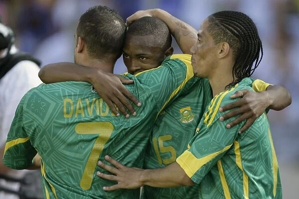 South Africas Parker celebrates with teammates Davids and Pienaar after scoring against Norway during Nelson Mandela soccer challenge in Rusternburg