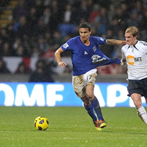 Intense Rivalry: Cahill vs. Holden's Battle for Ball Possession - Everton vs. Bolton Wanderers, Barclays Premier League (2011)