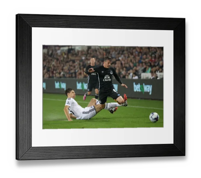 Framed Print : Battling for Control: Oviedo vs. Fernandez in the Intense Capital One Cup Clash between Swansea City and Everton Framed Print : Battling for Control: Oviedo vs. Fernandez in the Intense Capital One Cup Clash between Swansea City and Everton
