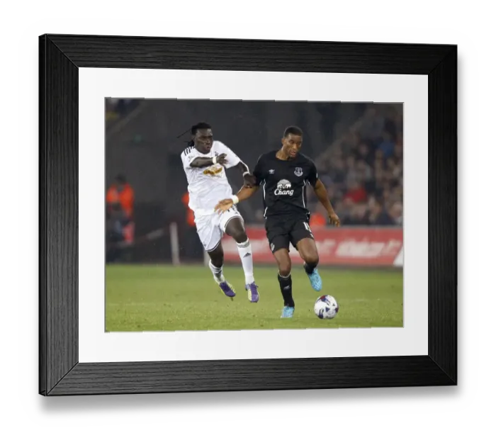 Framed Print : Distin vs. Gomis: A Battle for the Ball in Everton's Capital One Cup Clash at Swansea