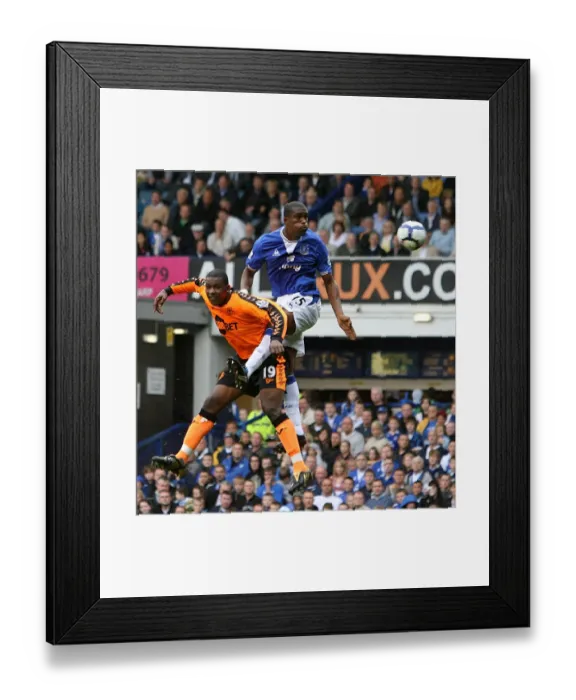 Framed Print : Distin's Dominance: Everton's Sylvain Distin Outjumps Wigan's Titus Bramble in Premier League Showdown at Goodison Park Framed Print : Distin's Dominance: Everton's Sylvain Distin Outjumps Wigan's Titus Bramble in Premier League Showdown at Goodison Park