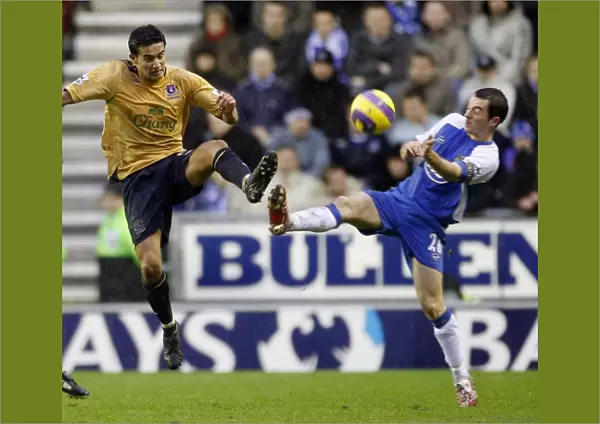 Wigan Athletics Baines challenges Evertons Cahill for the ball during their English Premier League