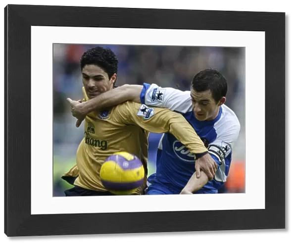 Wigan Athletics Baines challenges Evertons Arteta for the ball during their English Premier League