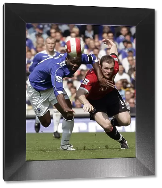 Evertons Yobo challenges Manchester Uniteds Rooney for the ball during their English Premier Leagu