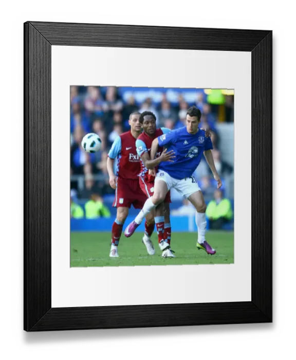 Framed Print : Battle for the Ball: Vellios vs. Makoun - Everton vs. Aston Villa Rivalry in the Barclays Premier League (04 April 2011)