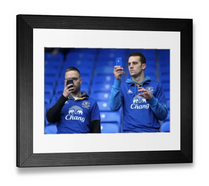 Framed Print : Everton vs Manchester United: Fans Capturing the Action at Goodison Park (2011) - Two Fans Taking Pictures with Mobile Phones during the Barclays Premier League Match Framed Print : Everton vs Manchester United: Fans Capturing the Action at Goodison Park (2011) - Two Fans Taking Pictures with Mobile Phones during the Barclays Premier League Match