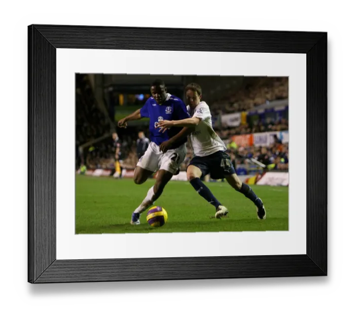 Framed Print : Anichebe vs. Gunter: Everton vs. Tottenham Clash in Barclays Premier League (January 30, 2008)