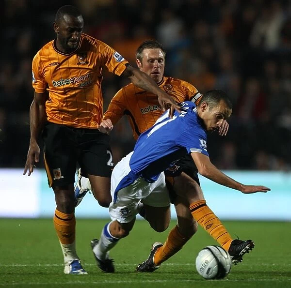 Determined Leon Osman's Battle: Everton vs. Hull City in Carling Cup - Overcoming Double Tackle from George Boateng and Nick Barmby
