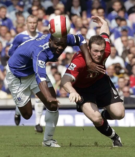 Evertons Yobo challenges Manchester Uniteds Rooney for the ball during their English Premier Leagu