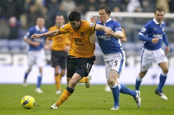 Intense Battle for Ball Possession: Stracqualursi vs Caldwell, Wigan Athletic vs Everton (04 February 2012)