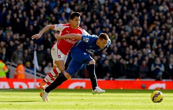 Intense Clash: Sanchez Tackles McCarthy in Arsenal vs. Everton (Barclays Premier League)