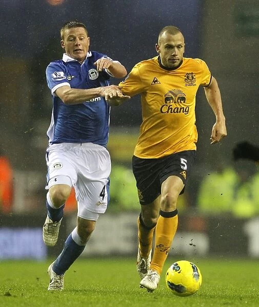 Intense Rivalry: Heitinga vs McCarthy's Battle for Ball Possession - Wigan Athletic vs Everton, Barclays Premier League (04 February 2012)