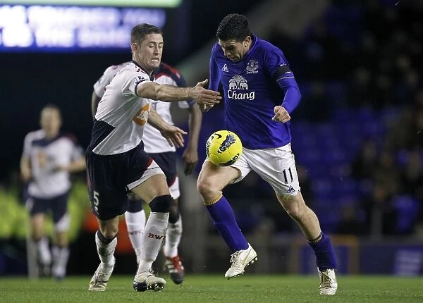 Intense Rivalry: Stracqualursi vs. Cahill's Battle for Ball Supremacy at Goodison Park - Everton vs. Bolton Wanderers, Barclays Premier League (04 January 2012)