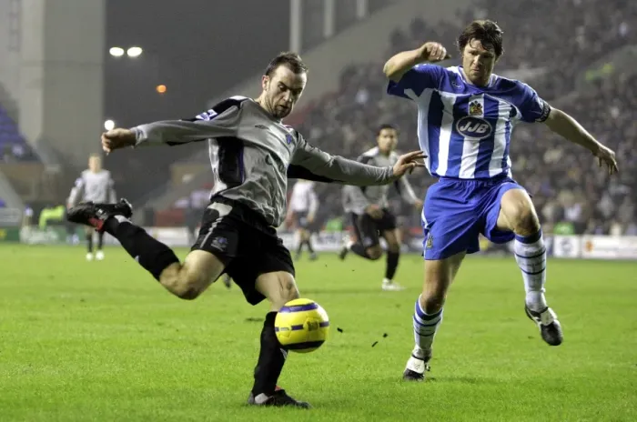 Framed Print : McFadden's Moment of Determination: Everton Star Faces Pressure from Wigan's Arjan De Zeeuw