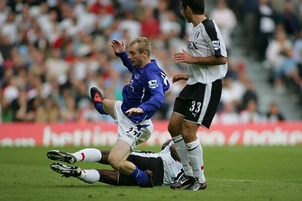 Tony Hibbert is felled by a pair of Bolton defenders