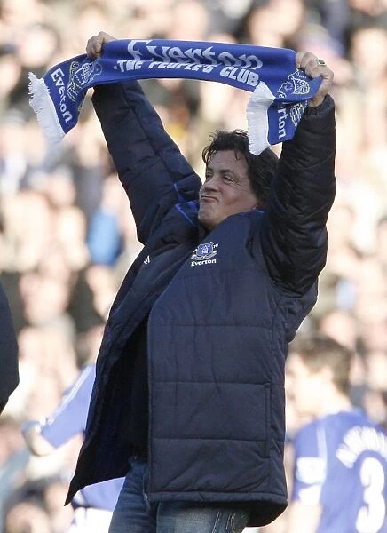 U. S. actor Stallone holds a scarf as he walks on the pitch at the English Premier League match betwe