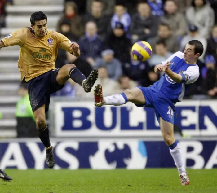 Framed Print : Wigan Athletics Baines challenges Evertons Cahill for the ball during their English Premier League