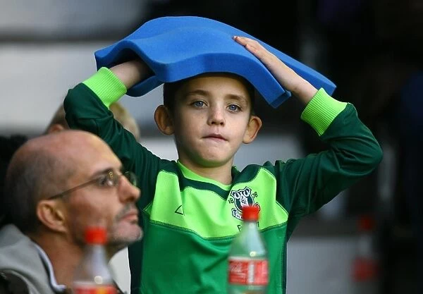 Young Everton Fan's Thrill: Giant Foam Hand at Goodison Park during Everton vs Stoke City (Premier League 2010)