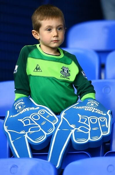 Young Everton Fan's Thrill: Giant Foam Hands at Packed Goodison Park before Everton vs Stoke City (BPL 2010)