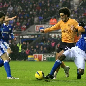 Everton's Fellaini Fights for Ball Against Wigan Athletic Duo in Premier League Clash Everton's Fellaini Fights for Ball Against Wigan Athletic Duo in Premier League Clash
