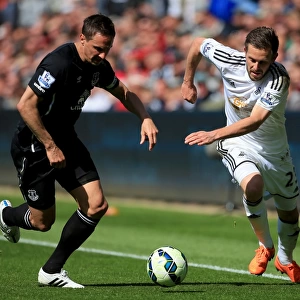 Intense Rivalry: Jagielka vs. Sigurdsson Battle at Swansea City vs. Everton (Barclays Premier League)