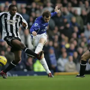 McFadden's Determination: Focused Shot Amidst Babayaro's Defensive Pressure McFadden's Determination: Focused Shot Amidst Babayaro's Defensive Pressure