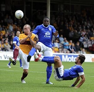 Images Dated 21st July 2012: Anichebe and Vellios vs. Law: Everton's Star Forwards Face Off in Pre-Season Clash at Fir Park