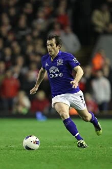 Images Dated 13th March 2012: Everton vs. Liverpool Rivalry: Leighton Baines Intense Battle at Anfield (13 March 2012)