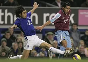 Everton v West Ham United Collection: Evertons Valente challenges West Ham Uniteds Tevez for the ball during their English Premier Leagu