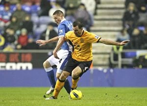 Images Dated 4th February 2012: Intense Rivalry: McCarthy vs. Gibson's Battle for Ball at Wigan Athletic's DW Stadium (Everton vs)