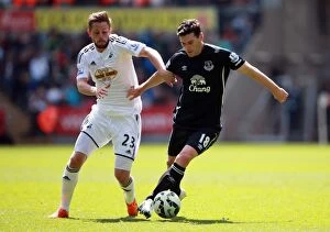 Images Dated 11th April 2015: Sigurdsson vs. Barry: A Battle of Midfield Maestros in Swansea City vs