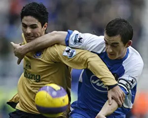 Wigan Athletics Baines challenges Evertons Arteta for the ball during their English Premier League